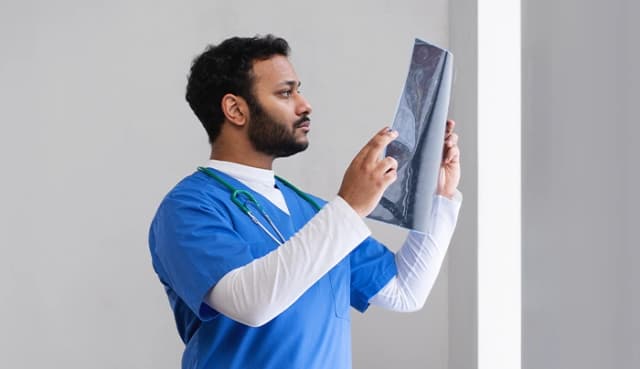 Radiology student examining x-ray film at Virohan